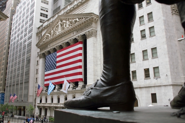 Image is of Stock Exchange with the American flag hung in front of the building.